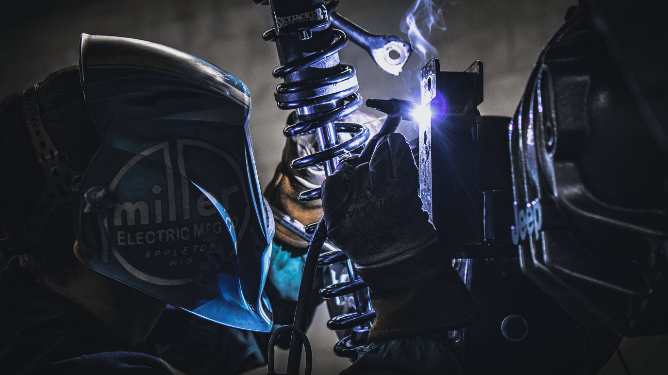 Mechanik naprawiający ciężarówkę, wykonujący spawanie części